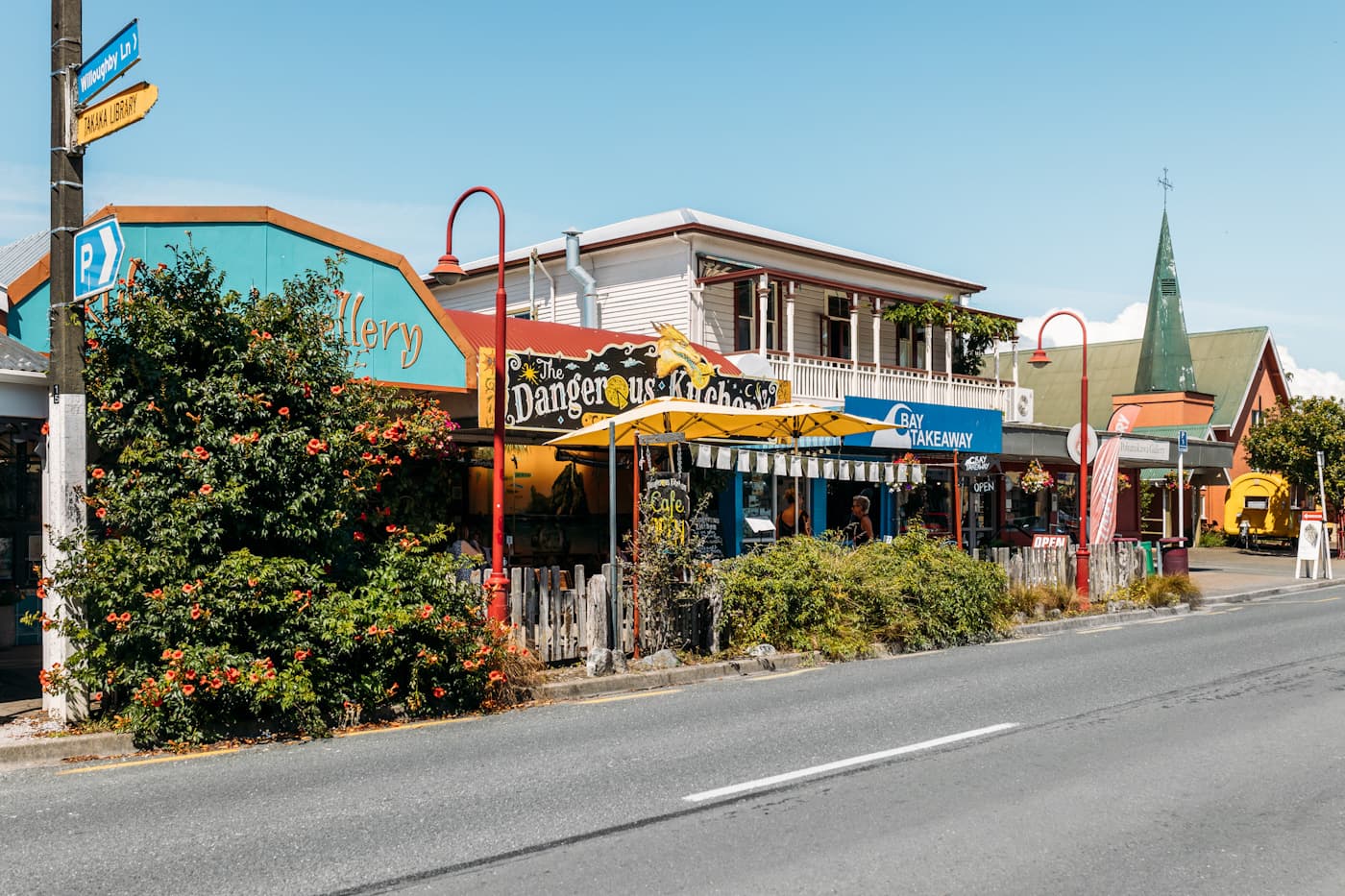 Street scene in Takaka with colourful shops, cafes and people in Golden Bay, New Zealand